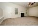 Spacious living room featuring neutral carpet, a fireplace, and large windows for natural light at 4438 Tuckahoe Ct, Douglasville, GA 30135