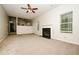 Open-concept living room featuring a fireplace, neutral carpet, and views into adjacent rooms at 4438 Tuckahoe Ct, Douglasville, GA 30135