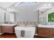 Bright bathroom featuring double vanities, a soaking tub, and modern fixtures at 455 Firelite Ln, Suwanee, GA 30024