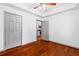 Bedroom boasts hardwood floors, ceiling fan, and view to the kitchen at 455 Firelite Ln, Suwanee, GA 30024