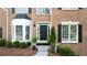 Inviting front entrance with a black door, decorative plants, and classic brickwork at 455 Firelite Ln, Suwanee, GA 30024