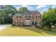 Beautiful brick home with a well-manicured lawn and mature trees showcasing classic architectural design at 455 Firelite Ln, Suwanee, GA 30024