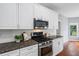 Close-up of kitchen area with granite countertops, stainless appliances, and white cabinetry at 455 Firelite Ln, Suwanee, GA 30024