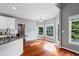 Bright kitchen and dining area features hardwood floors, white cabinets and large windows overlooking the deck at 455 Firelite Ln, Suwanee, GA 30024