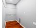 Laundry room with hardwood floors, light gray walls, and utility sink at 455 Firelite Ln, Suwanee, GA 30024
