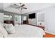 Main bedroom features hardwood floors, ceiling fan, tray ceiling and TV at 455 Firelite Ln, Suwanee, GA 30024