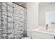 Modern bathroom features a shower with a curtain and a vanity with white counter and stainless faucet at 6555 Hawkins Manor Dr, Cumming, GA 30040