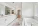 Serene bathroom with soaking tub, double sinks, and large mirror and marble floors at 6555 Hawkins Manor Dr, Cumming, GA 30040