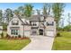Elegant brick home boasts a two-car garage, lush lawn, and inviting landscaping at 6555 Hawkins Manor Dr, Cumming, GA 30040