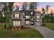 Charming brick home with manicured lawn, illuminated landscaping, and a welcoming entrance at 6555 Hawkins Manor Dr, Cumming, GA 30040