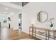 Bright entryway with wood floors, console table, decorative mirror, and open floorplan at 6555 Hawkins Manor Dr, Cumming, GA 30040