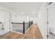 Bright hallway features wood flooring and a wrought iron railing at 6555 Hawkins Manor Dr, Cumming, GA 30040