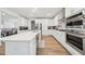 Bright, modern kitchen with stainless steel appliances, light hardwood floors and a large island at 6555 Hawkins Manor Dr, Cumming, GA 30040