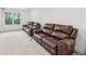 Recreation room featuring two leather sofas, carpet, and a window overlooking the yard at 6555 Hawkins Manor Dr, Cumming, GA 30040