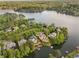 Expansive aerial view showcasing a waterfront neighborhood with private docks, lush landscaping, and stunning lake views at 1145 Lake Shore Overlook, Alpharetta, GA 30005