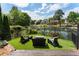 Private backyard with a fenced-in lake view, manicured lawn and outdoor seating at 1145 Lake Shore Overlook, Alpharetta, GA 30005