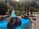 Tranquil backyard featuring a rock fountain, lush landscaping, and a serene lake view at 1145 Lake Shore Overlook, Alpharetta, GA 30005