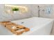 Close-up of a modern bathtub with a bamboo tray and elegant fixtures, perfect for a relaxing spa day at 1145 Lake Shore Overlook, Alpharetta, GA 30005