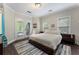 Bright bedroom features wood floors, access to patio, and a cozy faux fur comforter at 1145 Lake Shore Overlook, Alpharetta, GA 30005