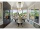 Bright dining room with fireplace, a chandelier, and large windows showcasing a lush outdoor view at 1145 Lake Shore Overlook, Alpharetta, GA 30005