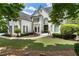 Charming two-story white brick home with a well-manicured lawn and lush landscaping at 1145 Lake Shore Overlook, Alpharetta, GA 30005