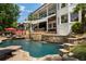 Stunning pool area featuring a waterfall, sun loungers, and outdoor bar for ultimate relaxation and entertainment at 1145 Lake Shore Overlook, Alpharetta, GA 30005