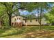 View of the rear of this two-story home, surrounded by mature trees and lush greenery at 218 Deerwood Se Ct, Smyrna, GA 30082