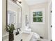 Bathroom featuring a stylish vanity, framed mirror, and window with wooded view at 218 Deerwood Se Ct, Smyrna, GA 30082