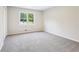An empty bedroom with carpeted floors and view of the tree-lined street at 218 Deerwood Se Ct, Smyrna, GA 30082