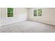 A bedroom with carpeted floors and two large windows bringing the green outdoors in at 218 Deerwood Se Ct, Smyrna, GA 30082