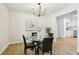 Elegant dining room with a glass table, black chairs, and modern light fixture at 218 Deerwood Se Ct, Smyrna, GA 30082