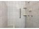 Close-up of a tiled shower with a grab bar and built-in shelving at 218 Deerwood Se Ct, Smyrna, GA 30082