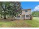 Spacious backyard showcasing a well-maintained lawn, mature trees, and the home's rear exterior at 2320 Crystal Ct, Loganville, GA 30052