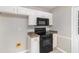 Efficient kitchen features a black range, microwave, and white cabinetry at 2320 Crystal Ct, Loganville, GA 30052