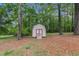 A wooden shed set among tall trees, providing extra storage space at 2320 Crystal Ct, Loganville, GA 30052