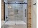 Shower over tub featuring glass doors and decorative tiling with a shower caddy at 235 Holly Nw Rd, Atlanta, GA 30314
