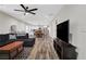Spacious living room with modern ceiling fan, sleek floors, and large TV for entertainment at 235 Holly Nw Rd, Atlanta, GA 30314