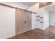 Stylish living room featuring an accent sliding barn door and sleek dark wood-look flooring at 408 Blue Sky Cir, Acworth, GA 30102
