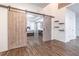 Large bedroom with tray ceiling, sliding barn doors, and wood-look floors at 408 Blue Sky Cir, Acworth, GA 30102