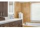 Spa-like bathroom featuring a soaking tub, wood cabinets, and a bright window at 4569 Fountain Ne Dr, Marietta, GA 30067