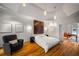 A spacious bedroom featuring hardwood floors, recessed lighting, and a sitting area with a cozy armchair at 4569 Fountain Ne Dr, Marietta, GA 30067