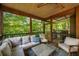 Covered porch with ample seating, ceiling fan, and barbecue overlooking a scenic backyard at 4569 Fountain Ne Dr, Marietta, GA 30067