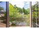 Balcony view through glass doors overlooking a private yard with lush, mature trees at 1100 Parker Ne Pl, Atlanta, GA 30324