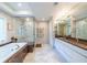Luxurious bathroom featuring a soaking tub, glass-enclosed shower, double vanities, and elegant marble accents at 1100 Parker Ne Pl, Atlanta, GA 30324