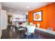 Modern dining area featuring a white table, vibrant orange wall, and sleek kitchen in the background at 1100 Parker Ne Pl, Atlanta, GA 30324