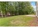 A sprawling lawn meets a wooded area in the spacious backyard at 1931 Abinger Way, Lawrenceville, GA 30043