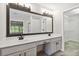 Bathroom with a large mirror, double sinks, vanity with cabinets, and a view into the walk-in closet at 1931 Abinger Way, Lawrenceville, GA 30043