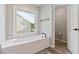 Bathroom featuring a soaking tub with a window view and tile floors at 1931 Abinger Way, Lawrenceville, GA 30043