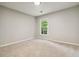 An empty bedroom with carpeted floors and a window providing natural light at 1931 Abinger Way, Lawrenceville, GA 30043
