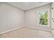 Bedroom with a window and tan carpet at 1931 Abinger Way, Lawrenceville, GA 30043